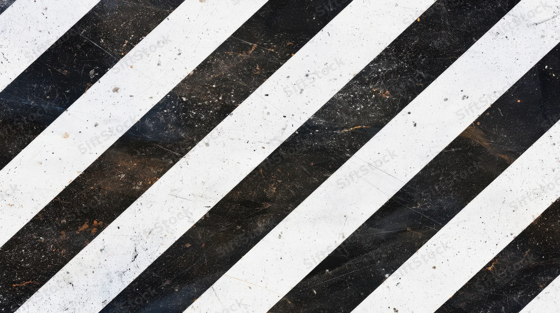 Diagonal black and white stripes on a weathered asphalt surface