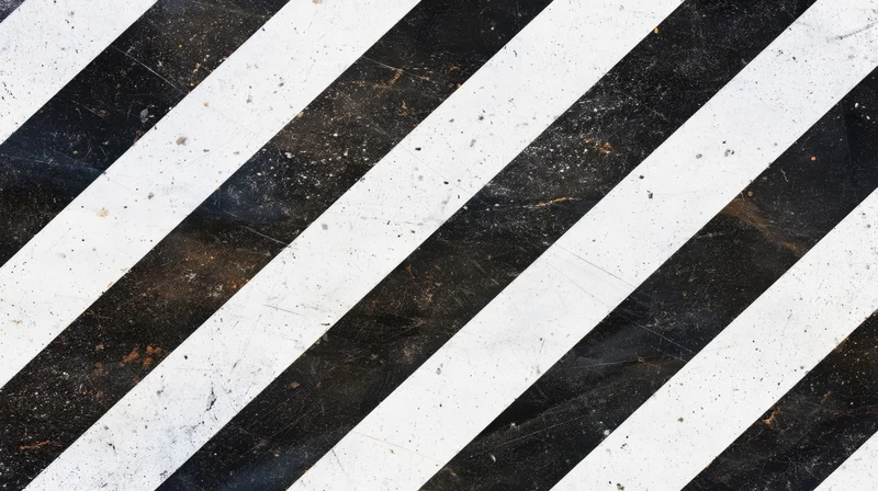 Diagonal black and white stripes on a weathered asphalt surface