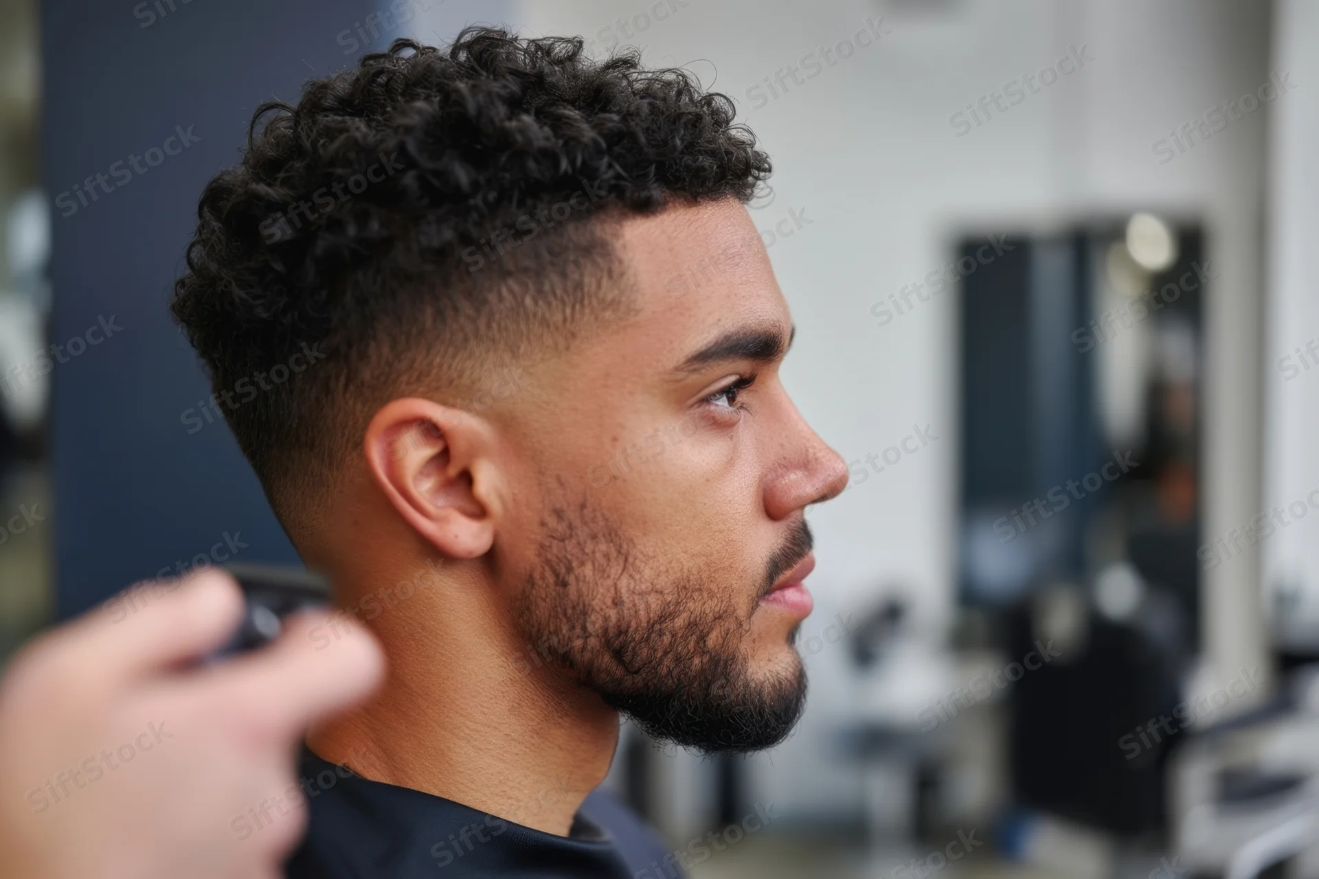 Man receiving haircut with clippers in barbershop side profile