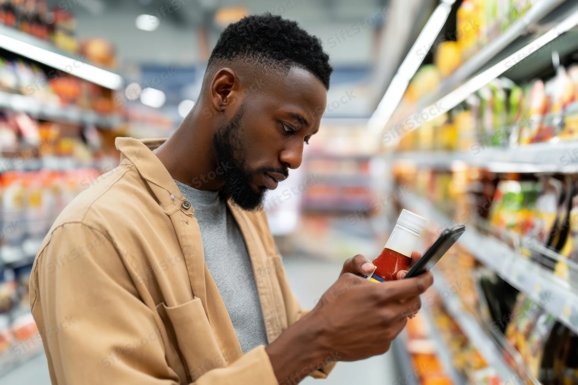 Man scanning sauce bottle label with smartphone in supermarket aisle