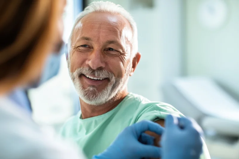 Senior man smiling during vaccination in a clinic