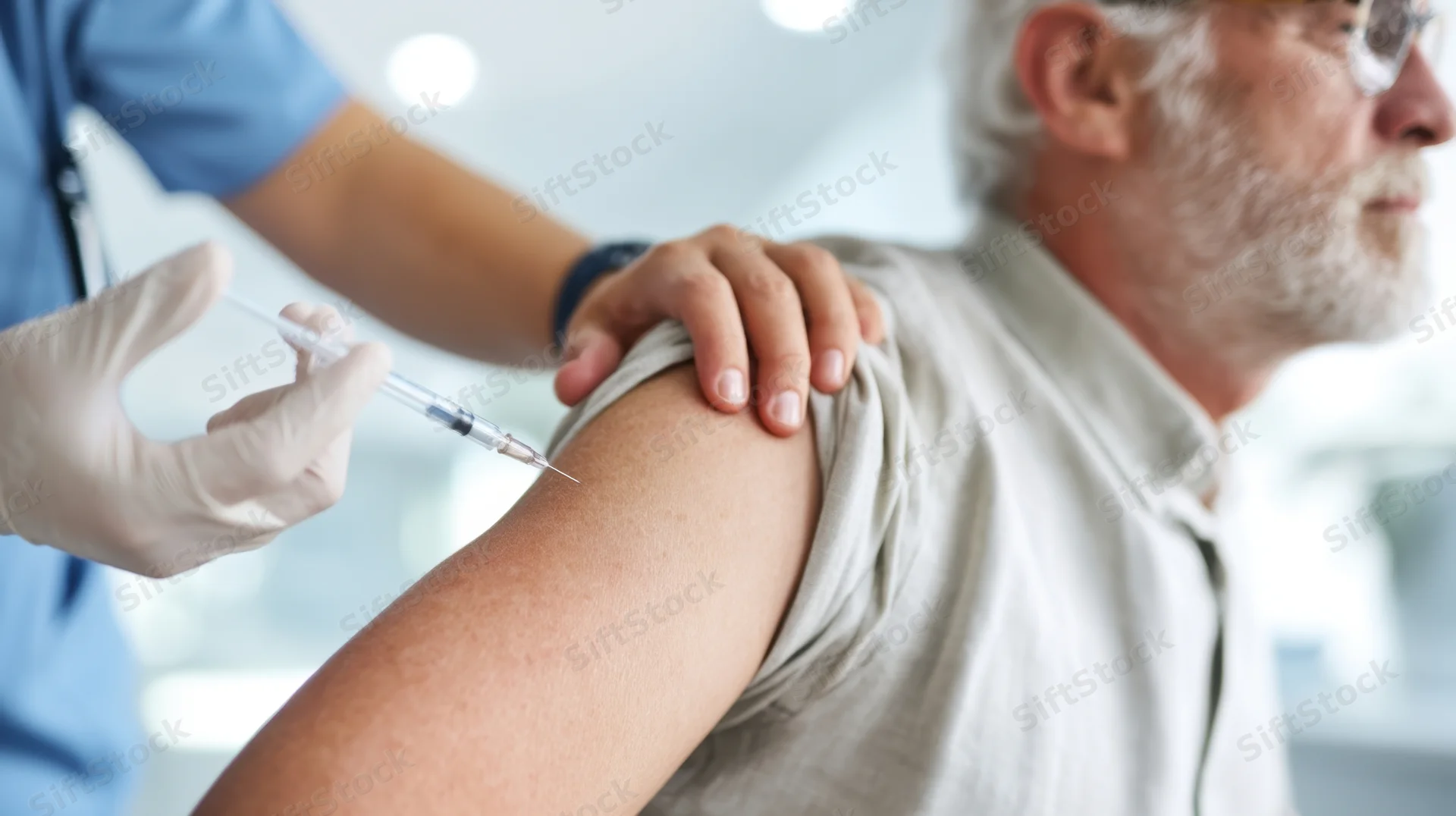 Senior man receiving injection in arm at clinic