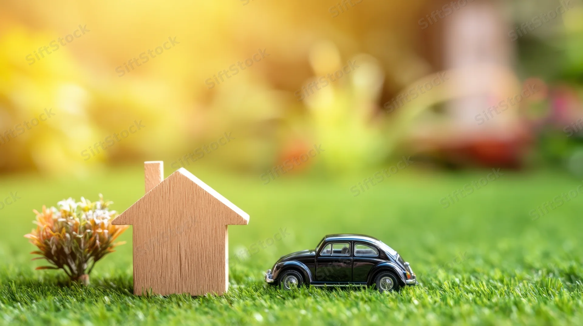 Wooden house and black vintage car model on green grass lawn