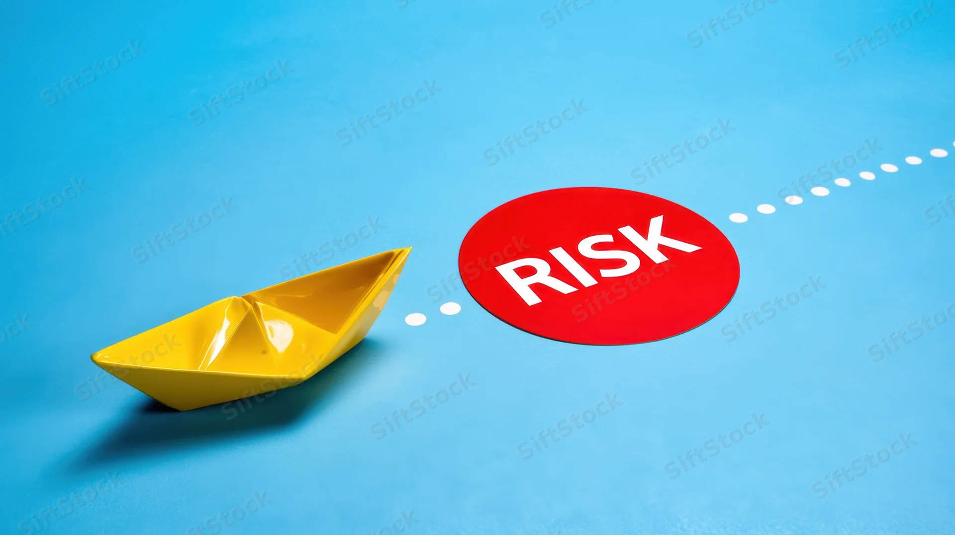 Yellow paper boat on blue surface approaching red circle labeled risk along dotted path