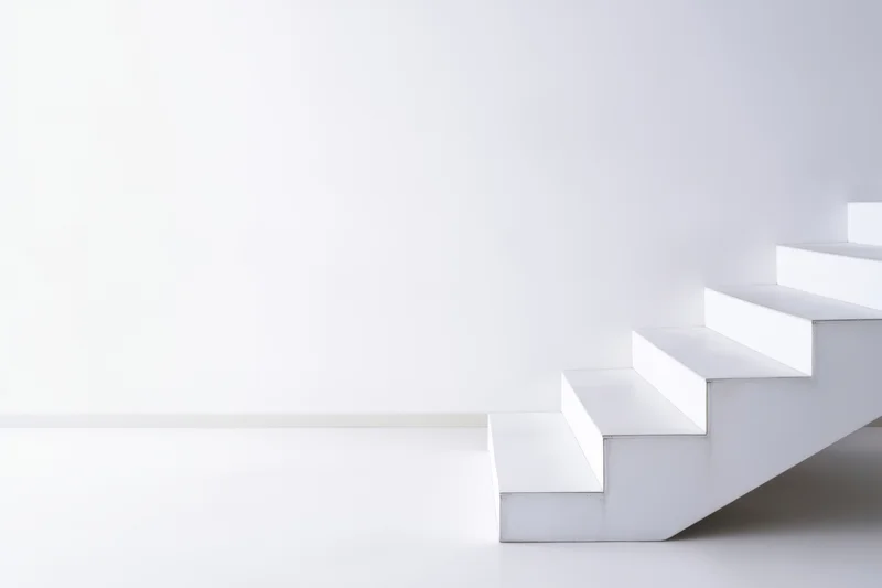White staircase ascending in a minimalist interior with copyspace