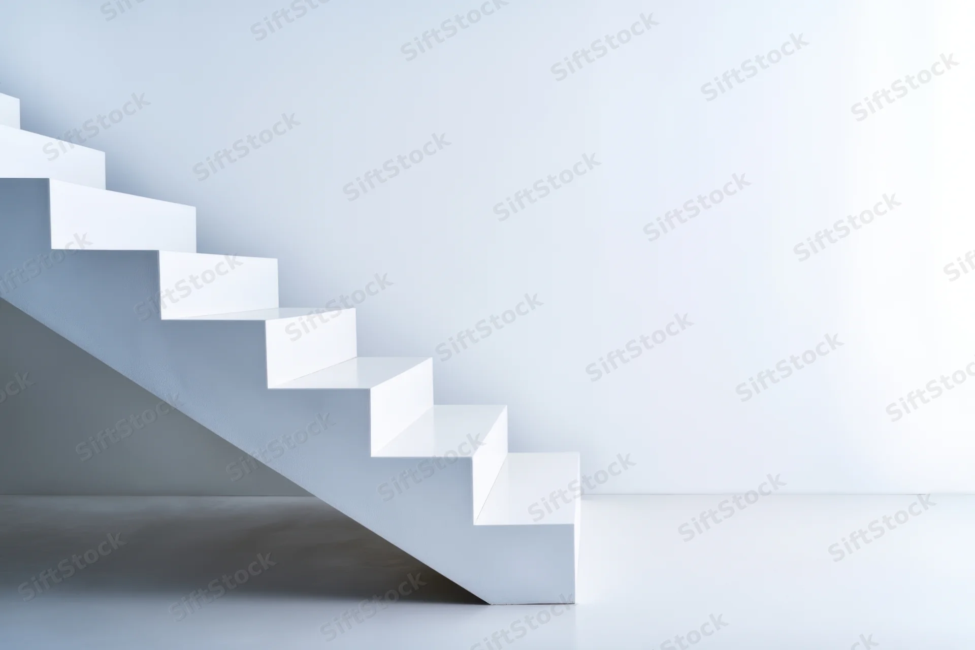 White minimalist staircase ascending in a bright empty interior space