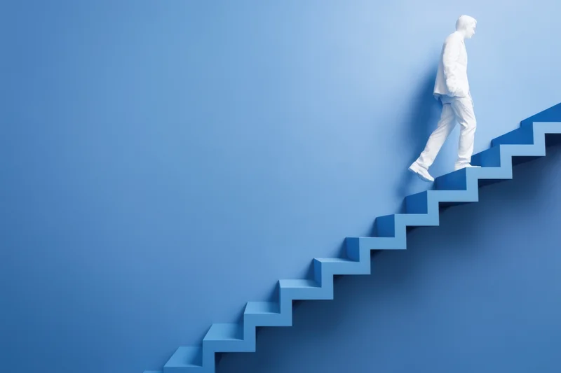Man climbing blue staircase in minimalist setting
