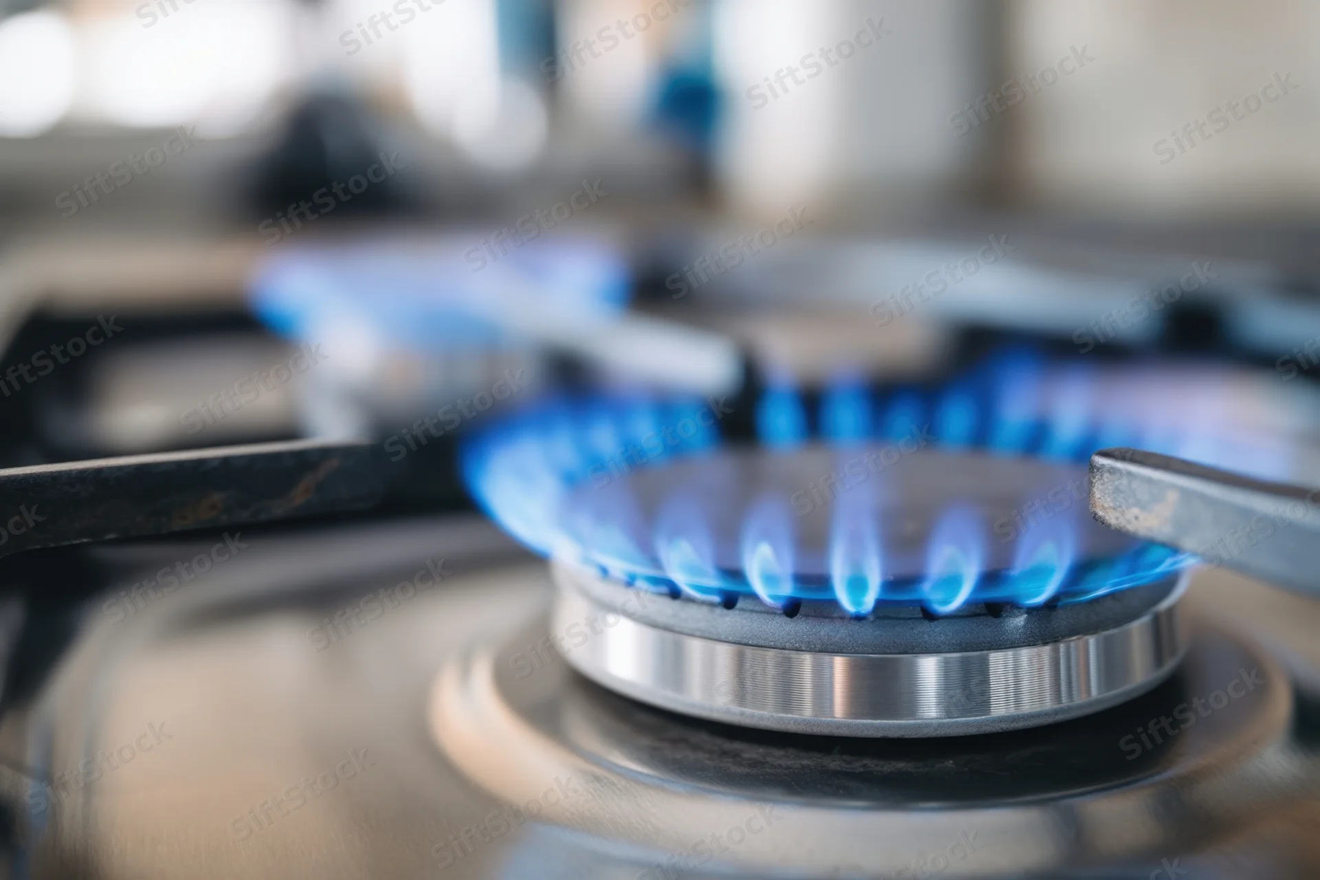 Blue flame burning on a gas stove burner in a kitchen
