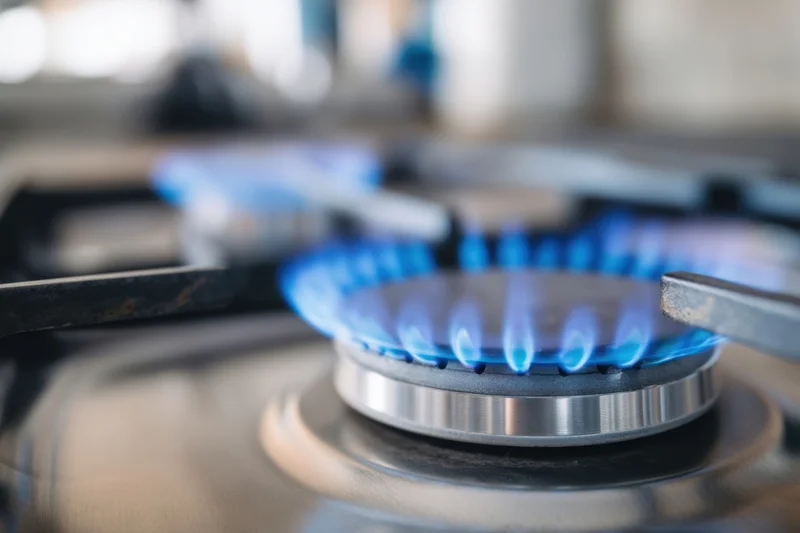 Blue flame burning on a gas stove burner in a kitchen