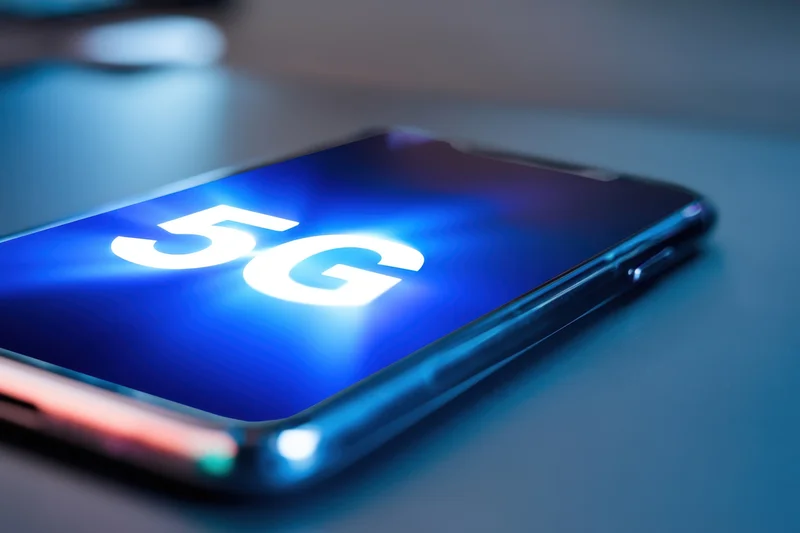 Smartphone displaying 5g on its screen resting on a surface