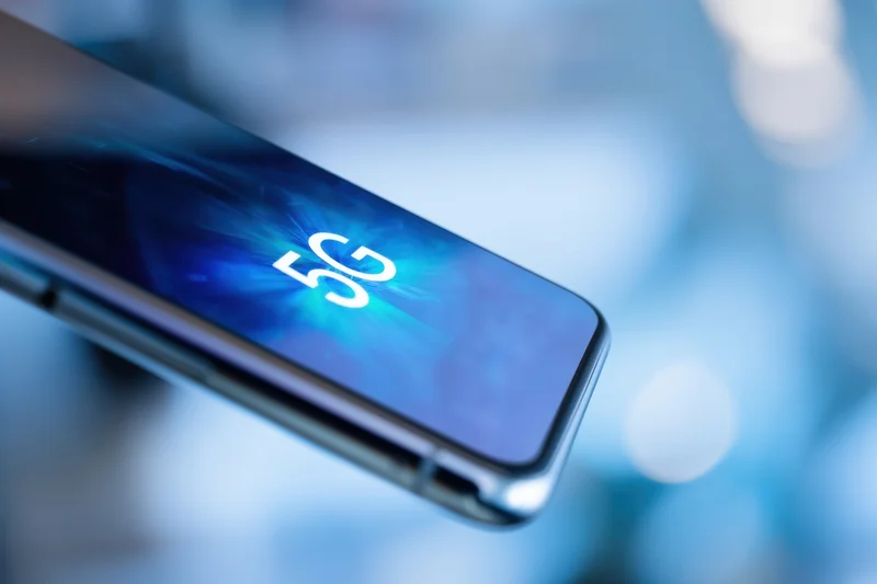 Smartphone screen displaying 5g symbol against blue abstract background
