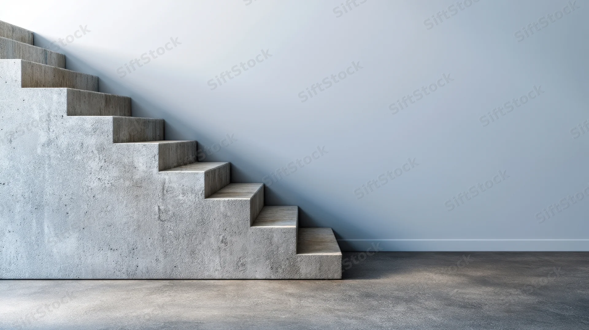 Concrete staircase ascending along a plain wall in a modern interior space