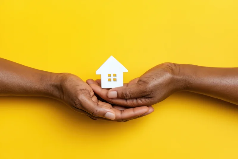 Two hands holding a white house cutout against a yellow background