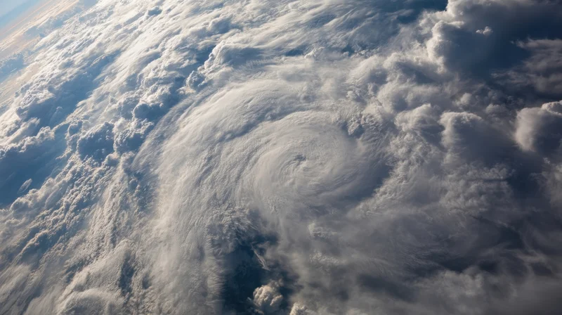 Satellite view of a rotating hurricane over the ocean with dense cloud cover