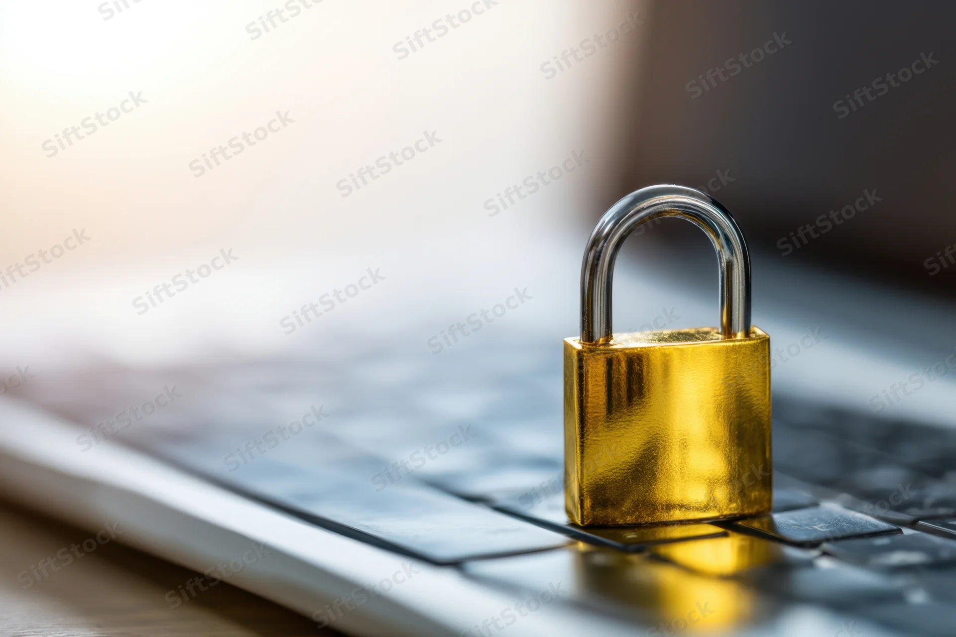 Gold padlock resting on laptop keyboard symbolizing digital security