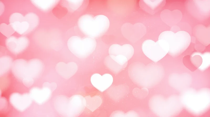 Soft pink background with glowing heart shapes in bokeh effect