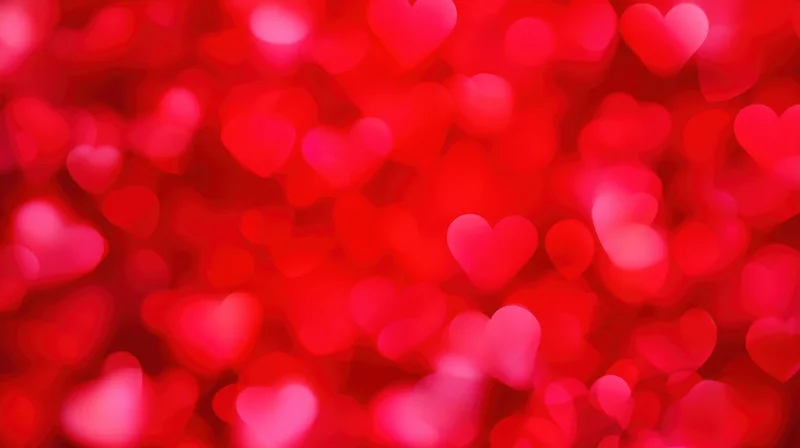 Blurred red heart shapes in soft focus as a romantic background