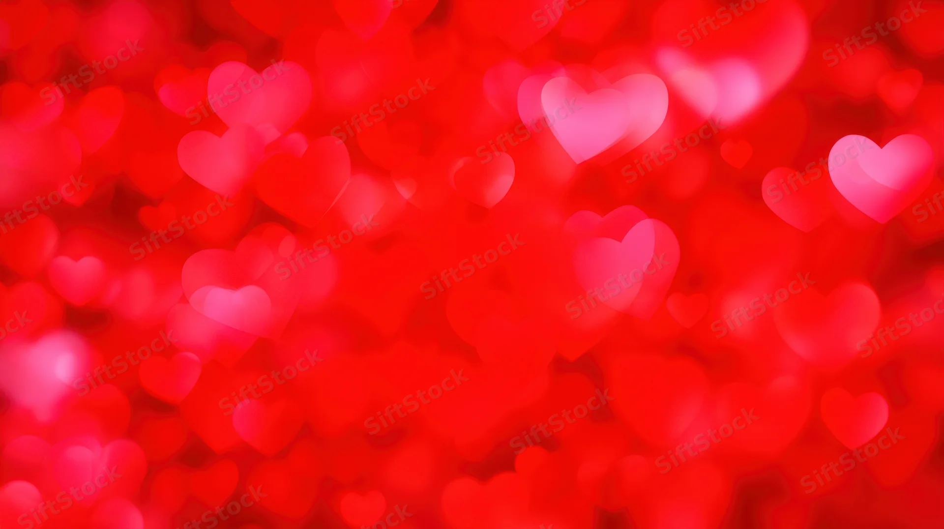 Blurred red heart shapes glowing softly as a romantic background