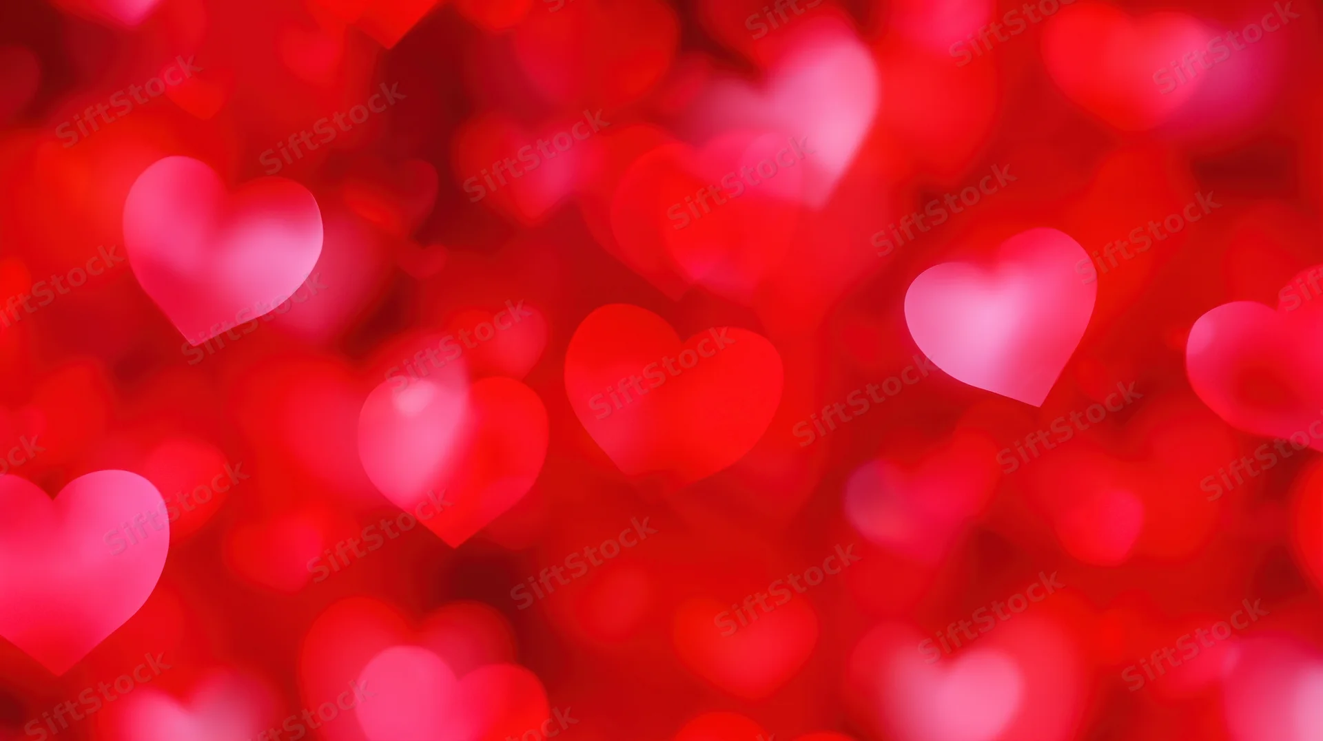 Blurred red heart shapes glowing softly as a romantic background