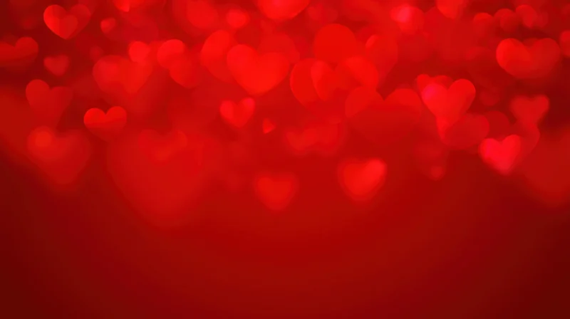 Red heart-shaped bokeh lights floating against a blurred background