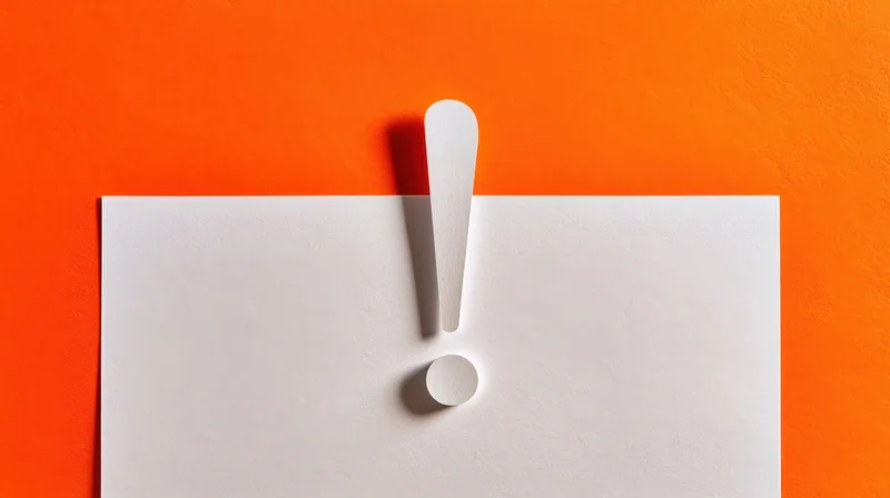 White paper with cutout exclamation mark on orange background