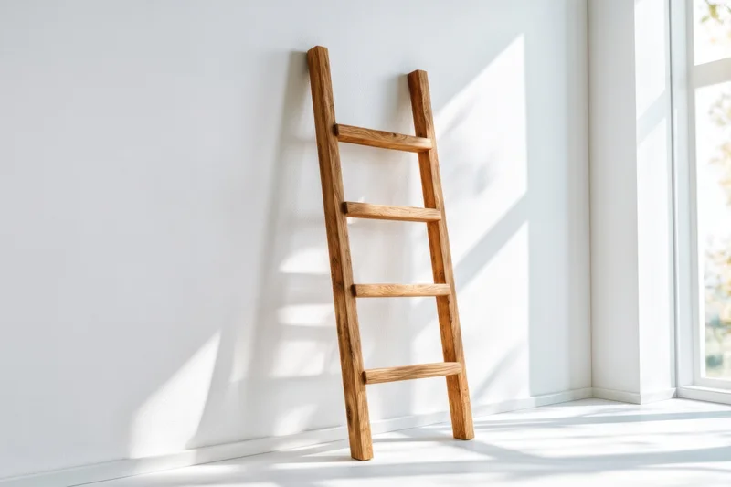 Wooden ladder leaning against white wall in bright minimalist room near window