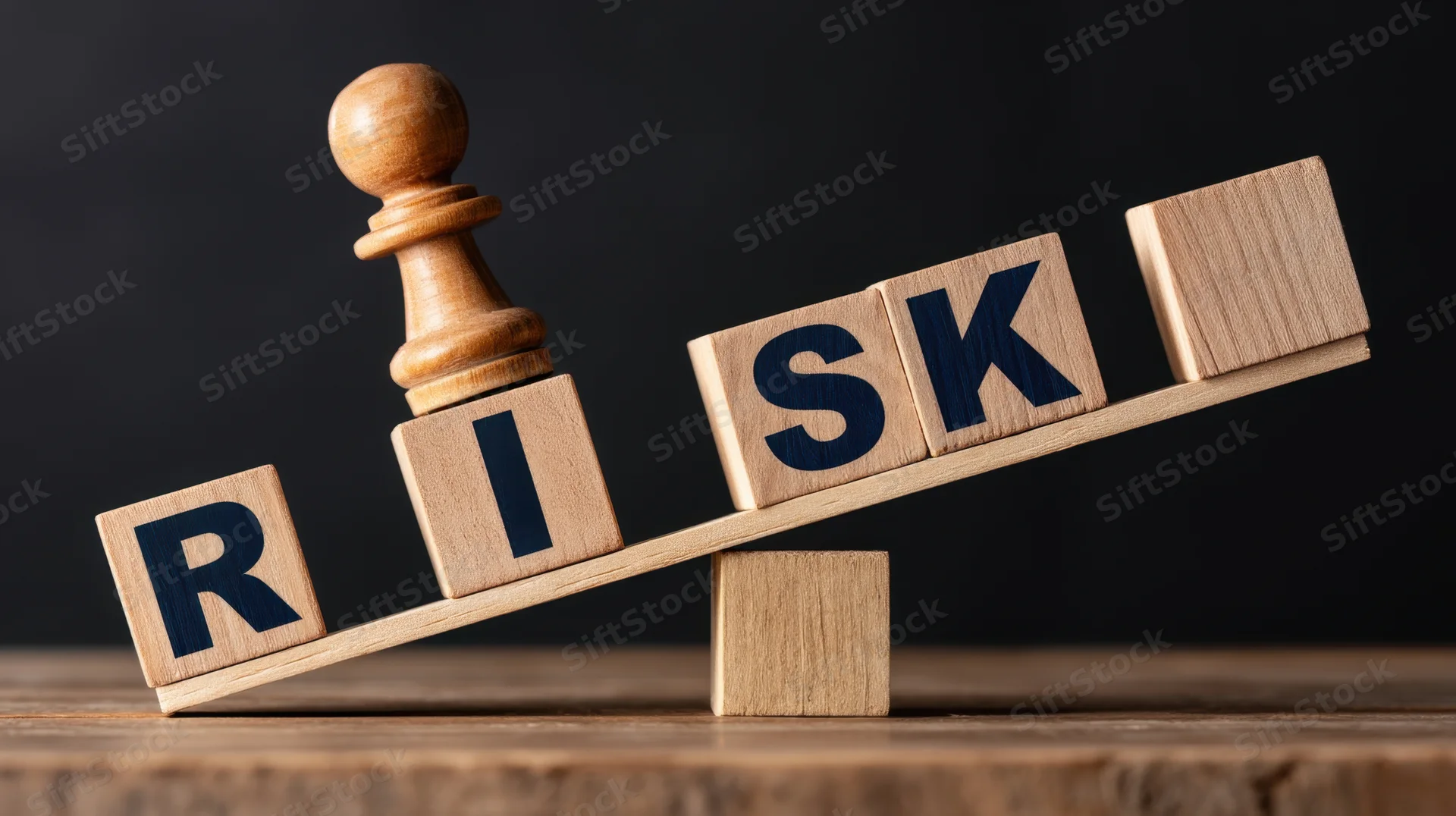 Wooden blocks spelling risk balanced on a seesaw with a chess pawn on top