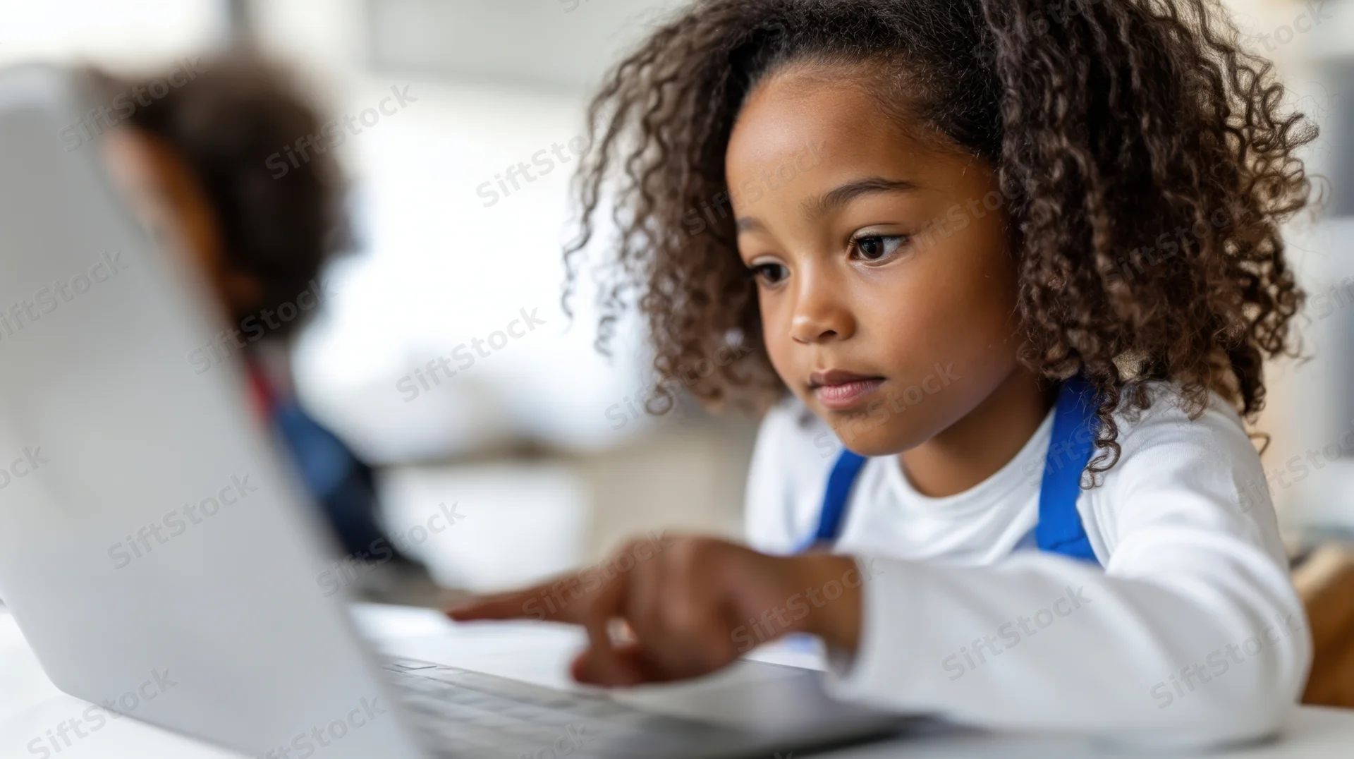 Young africanamerican girl pointing at laptop screen while studying indoors