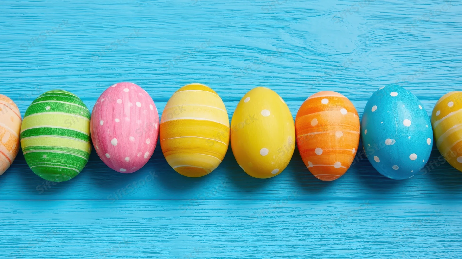 Decorated easter eggs in a row on a blue wooden surface