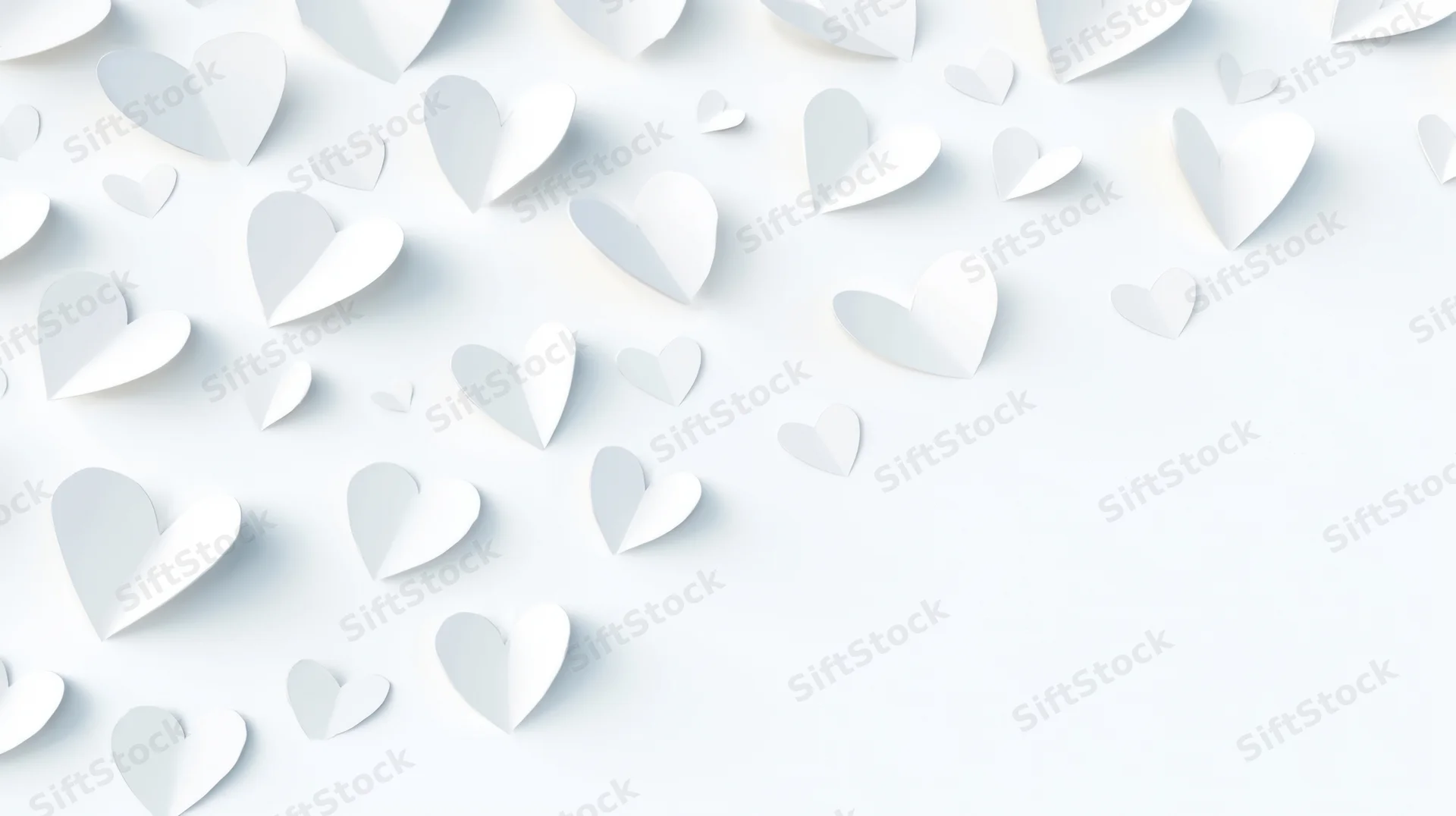 White paper hearts scattered across a light surface with copyspace on the right