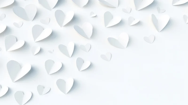 White paper hearts scattered across a light surface with copyspace on the right
