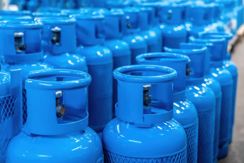 Rows of blue propane cylinders stored in a warehouse facility