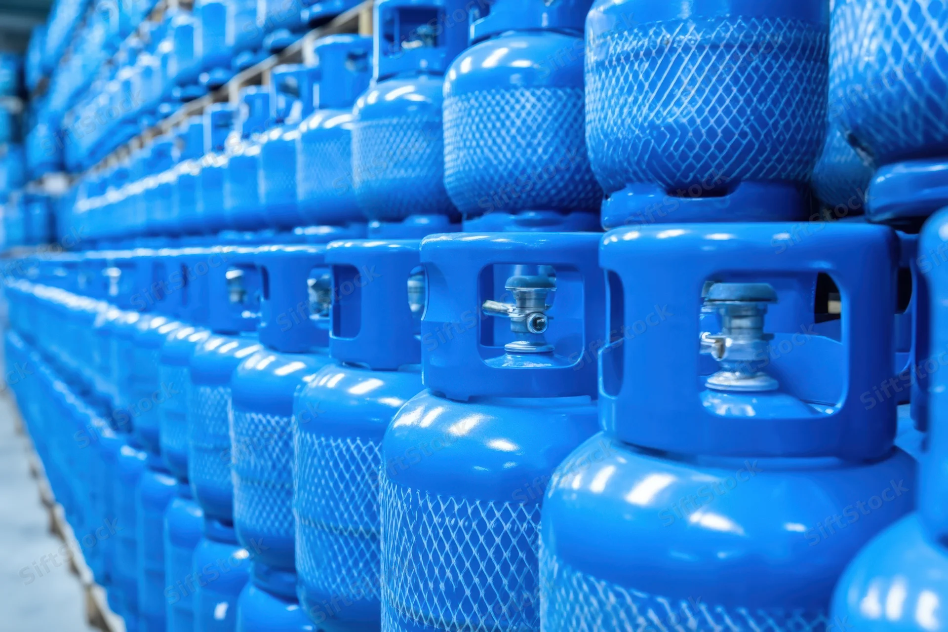 Rows of blue propane cylinders stacked in a warehouse storage facility