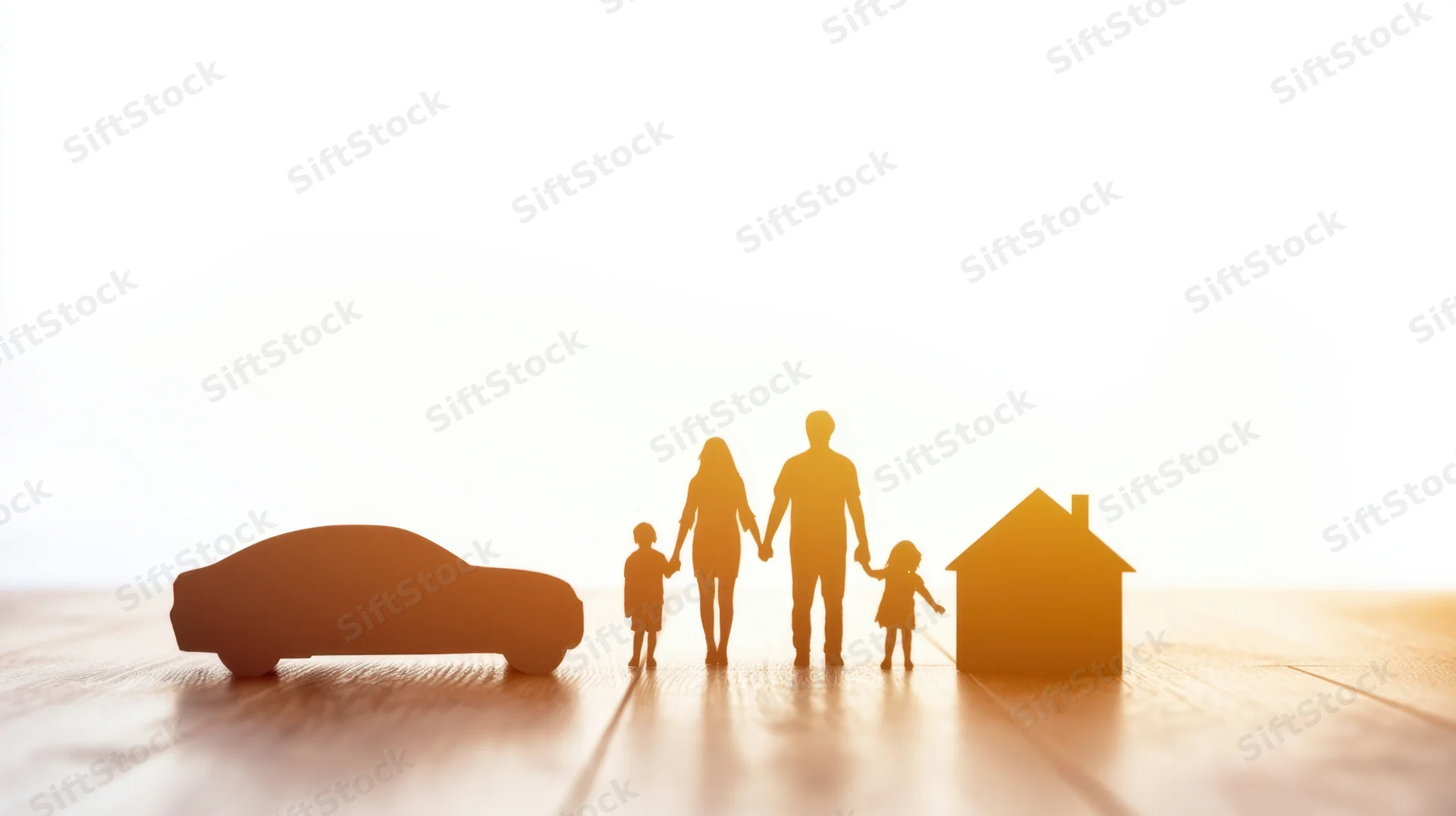 Family silhouette with car and house cutouts on wooden floor