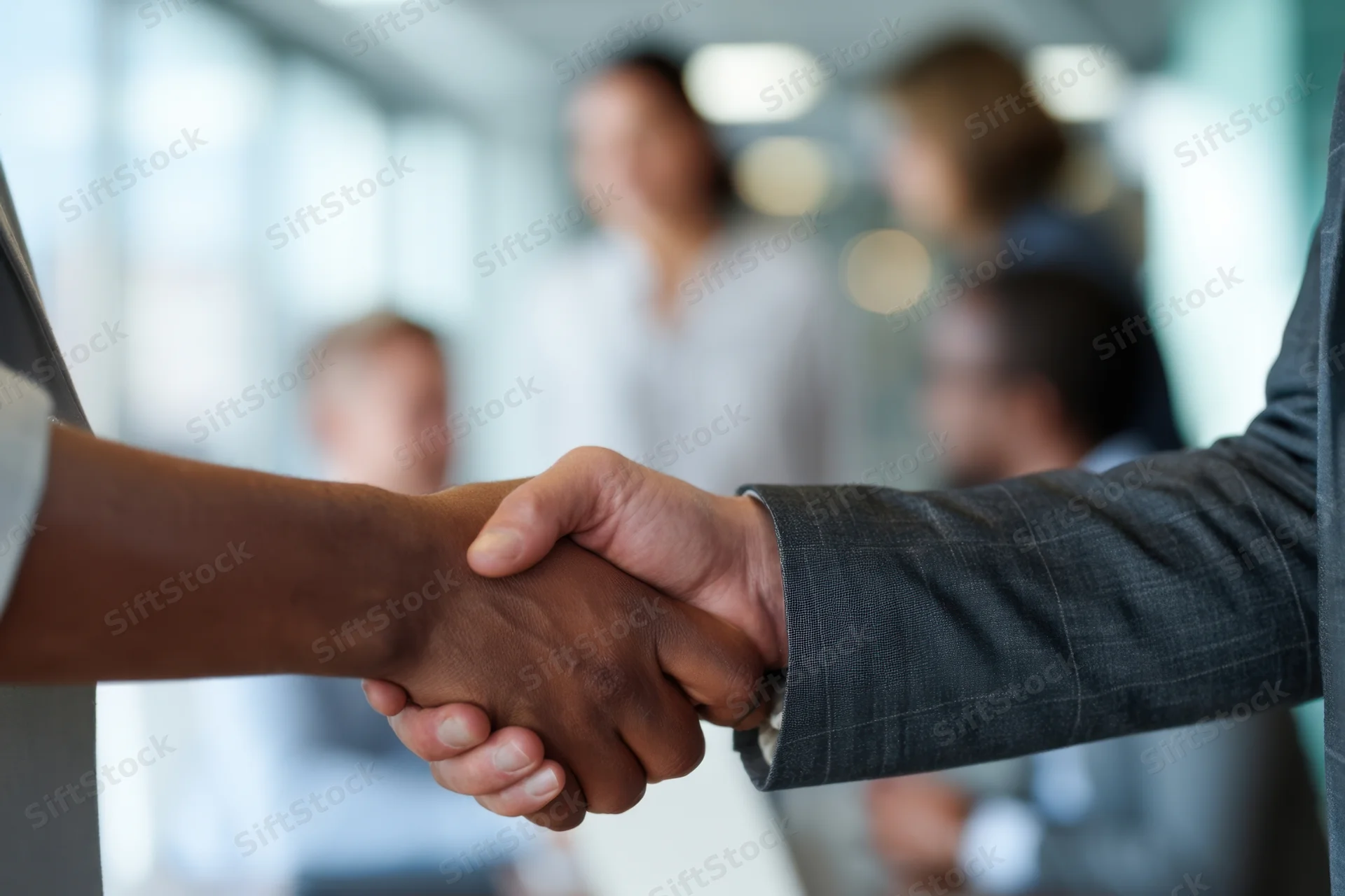 Two professionals shaking hands in a modern office setting