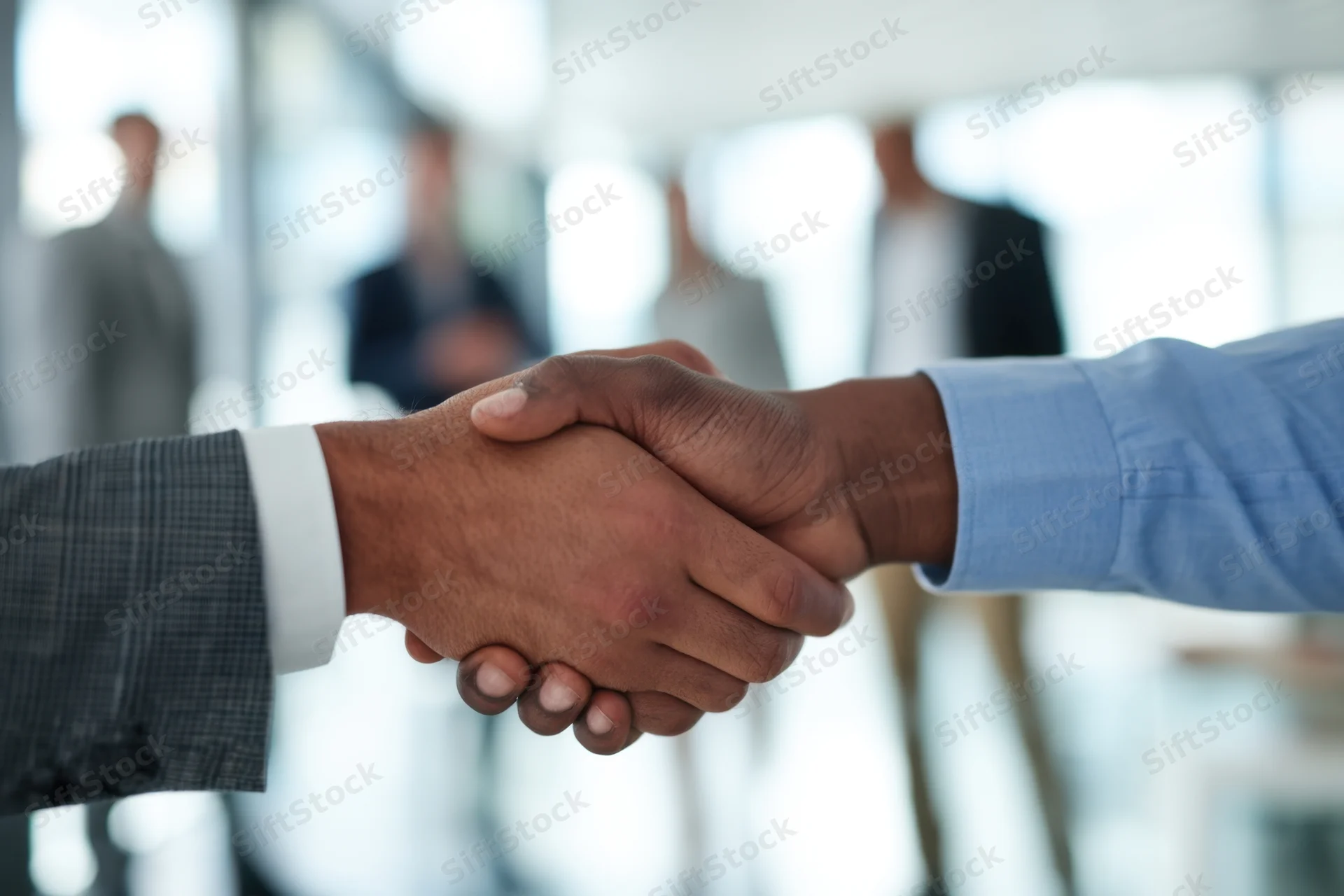 Two professionals shaking hands in a modern office setting