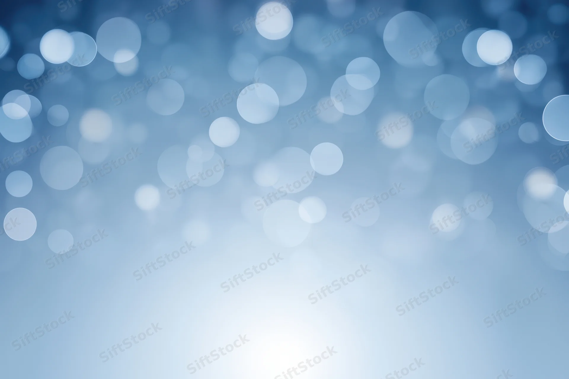 Soft blue gradient with white bokeh light circles as abstract background