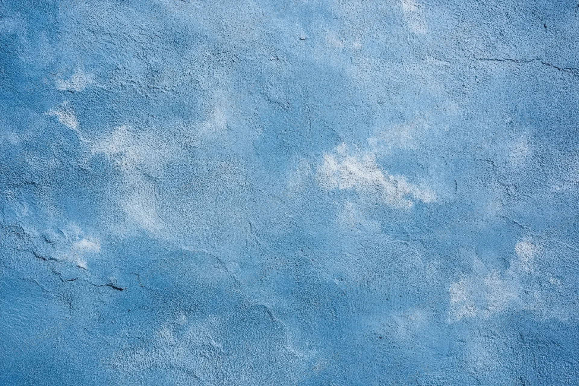 Blue textured plaster wall with white patches and cracks