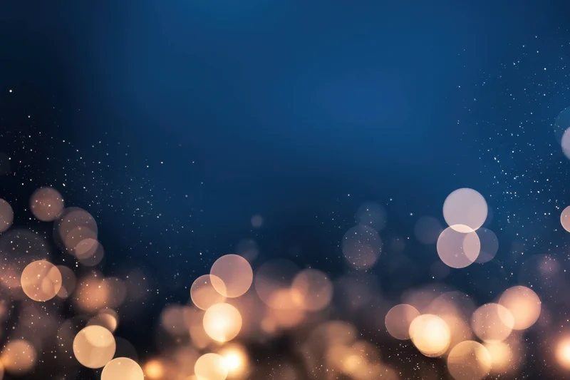 Soft warm bokeh lights on a deep blue gradient background with sparkling particles