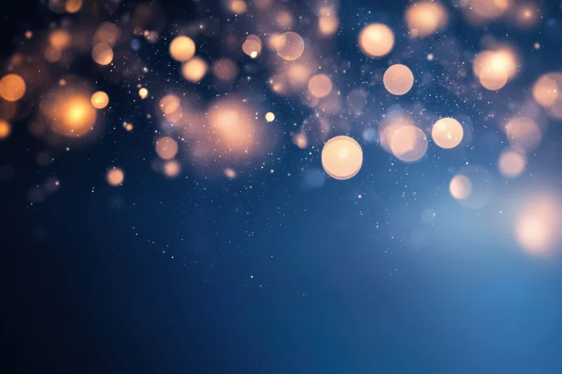 Soft warm bokeh lights on a deep blue gradient background with sparkling particles