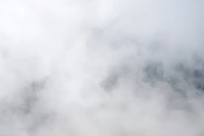 Swirling white fog over a soft gray sky