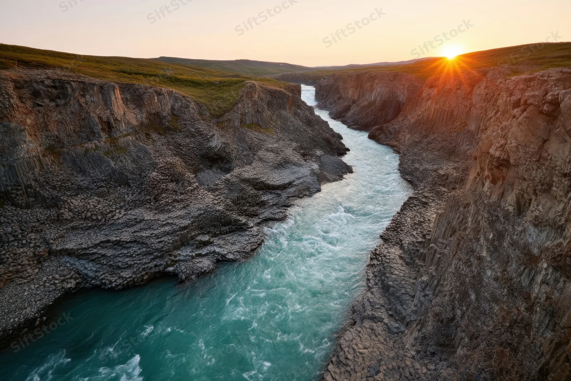Turquoise river flowing through hexagonal basalt canyon at sunset
