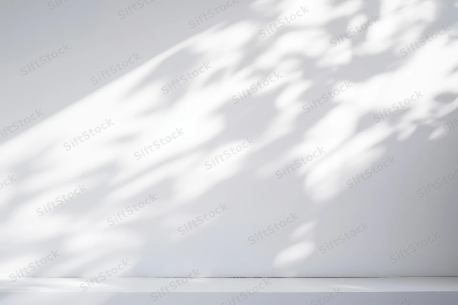 Minimalist white interior with dappled sunlight shadows on smooth wall and floor