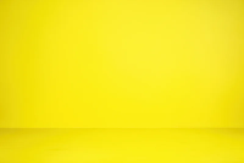 Seamless yellow studio backdrop with smooth wall and floor