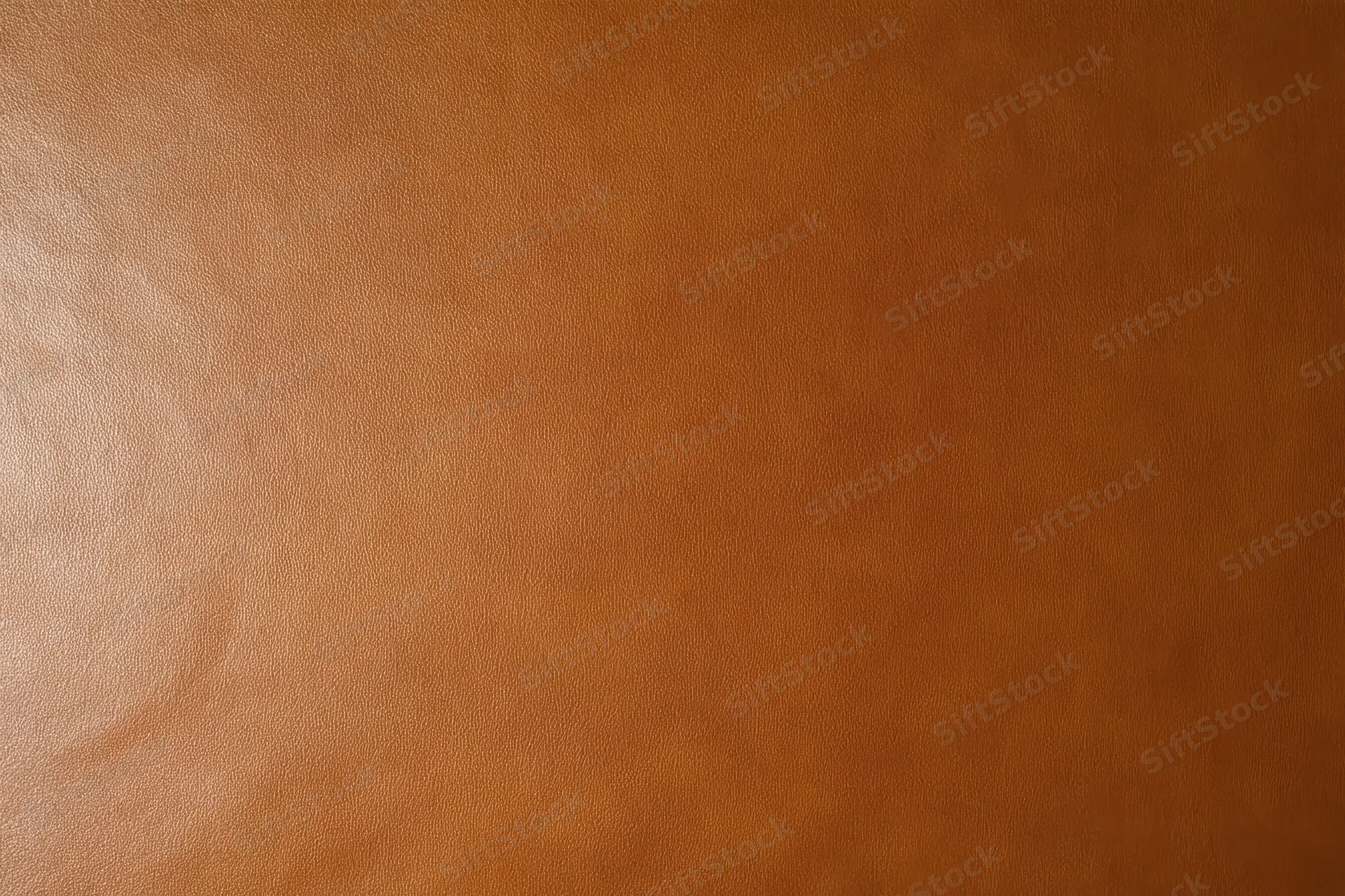 Close-up of smooth warm brown leather texture filling the frame