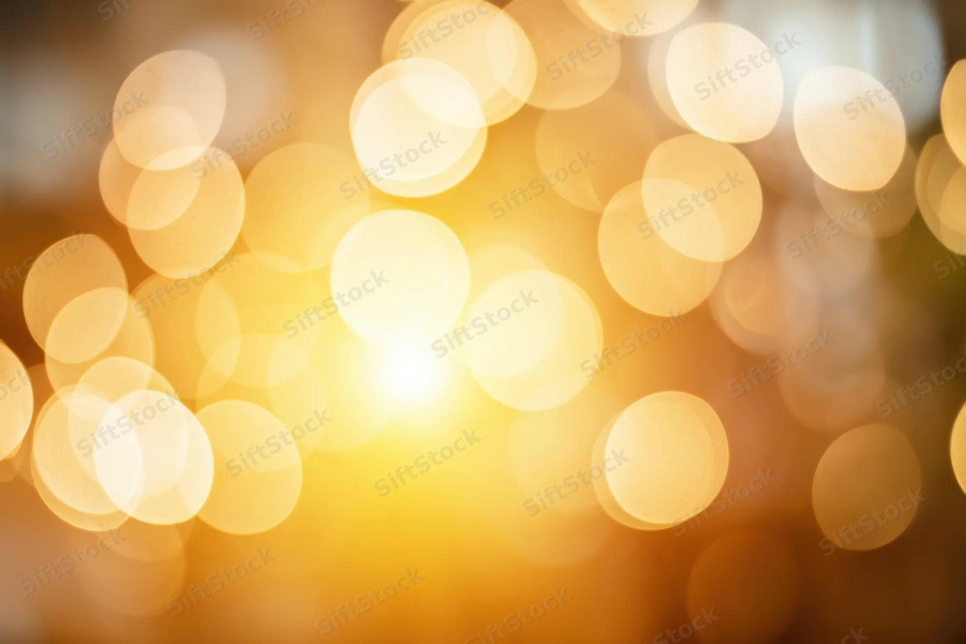 Soft golden bokeh lights with warm glow and circular highlights in a blurred festive background