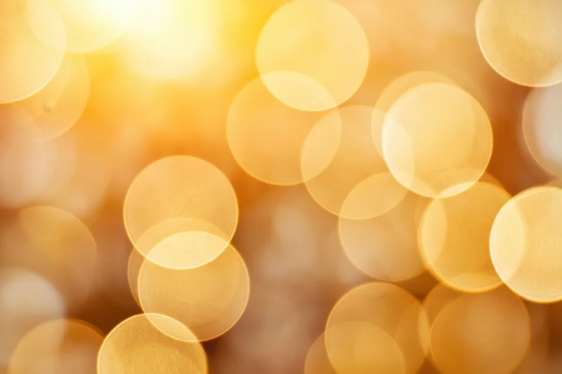 Golden bokeh lights creating a soft warm glow as a festive background