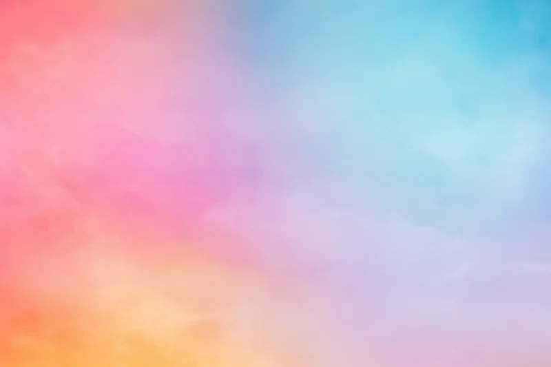 Soft pastel gradient blending pink blue and orange across a dreamy sky background