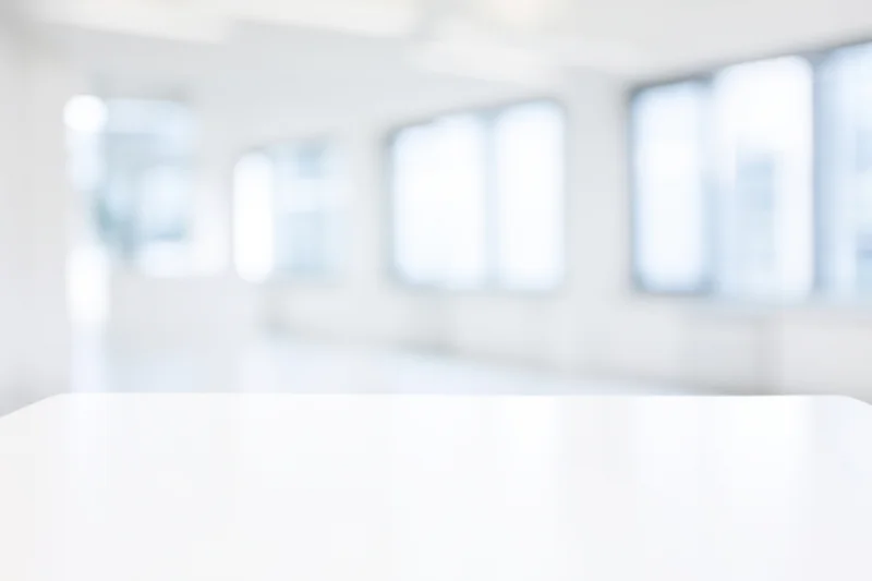White table in a bright modern studio interior with blurred background