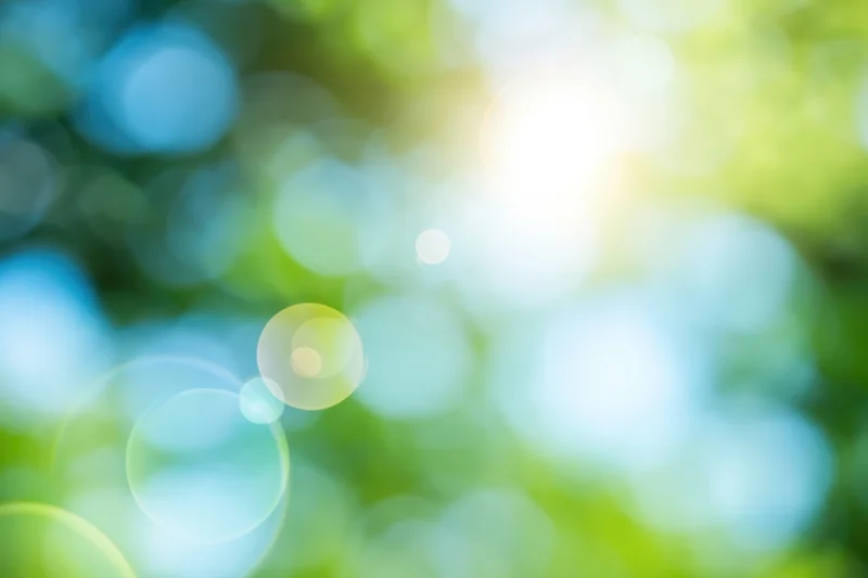 Sunlit abstract nature background with soft green and blue bokeh